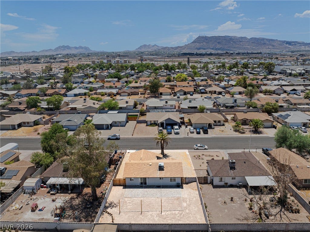 525 Van Dornum Avenue, Henderson, NV 89011 An aerial panorama reveals a vast residential community nestled against a majestic mountain range.