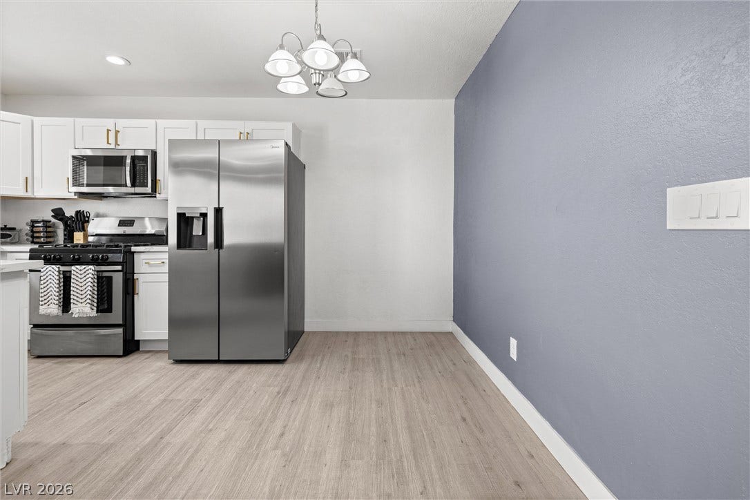 525 Van Dornum Avenue, Henderson, NV 89011 A contemporary kitchen space boasts stainless steel appliances and durable wood flooring.