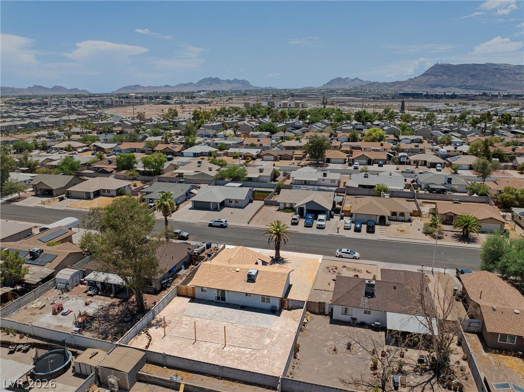 525 Van Dornum Avenue, Henderson, NV 89011 An aerial perspective showcases a residential neighborhood nestled against a distant mountainous backdrop.