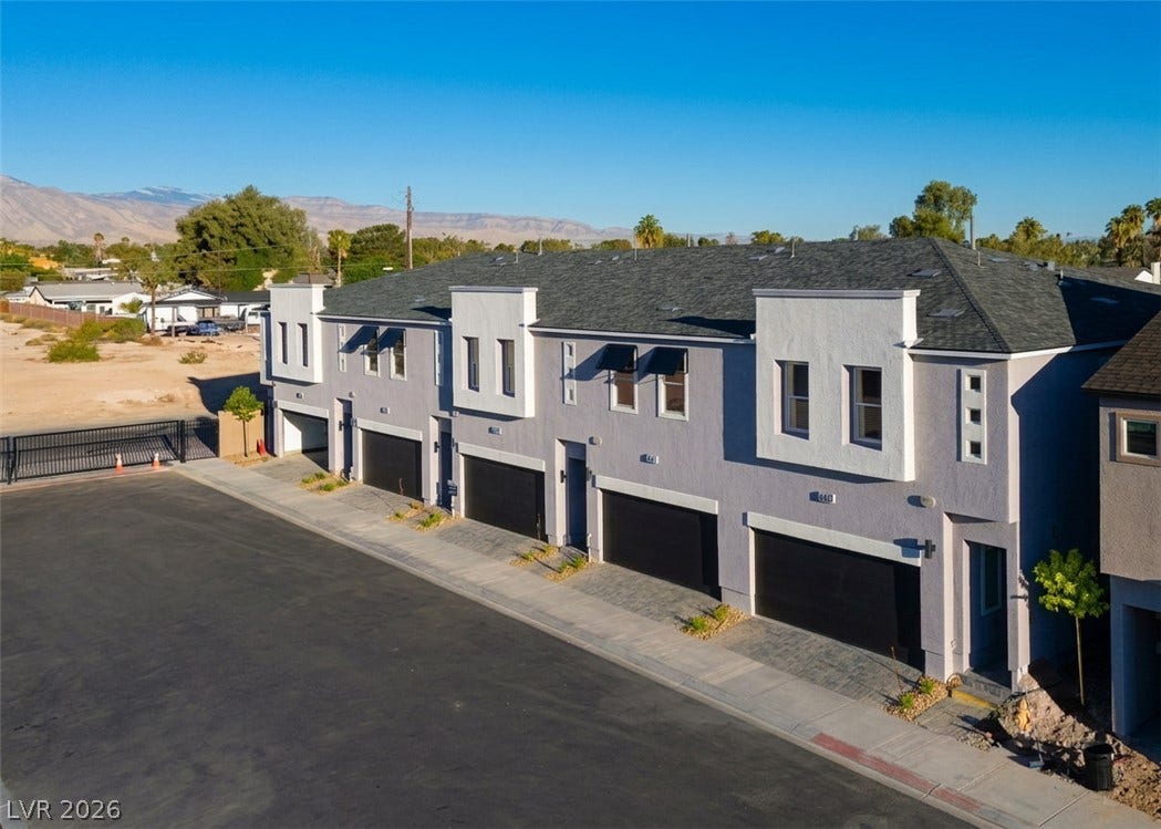 4926 Sweet Vesper Court, Las Vegas, NV 89108 Modern multi-unit architecture framed by mountains under a clear desert sky.