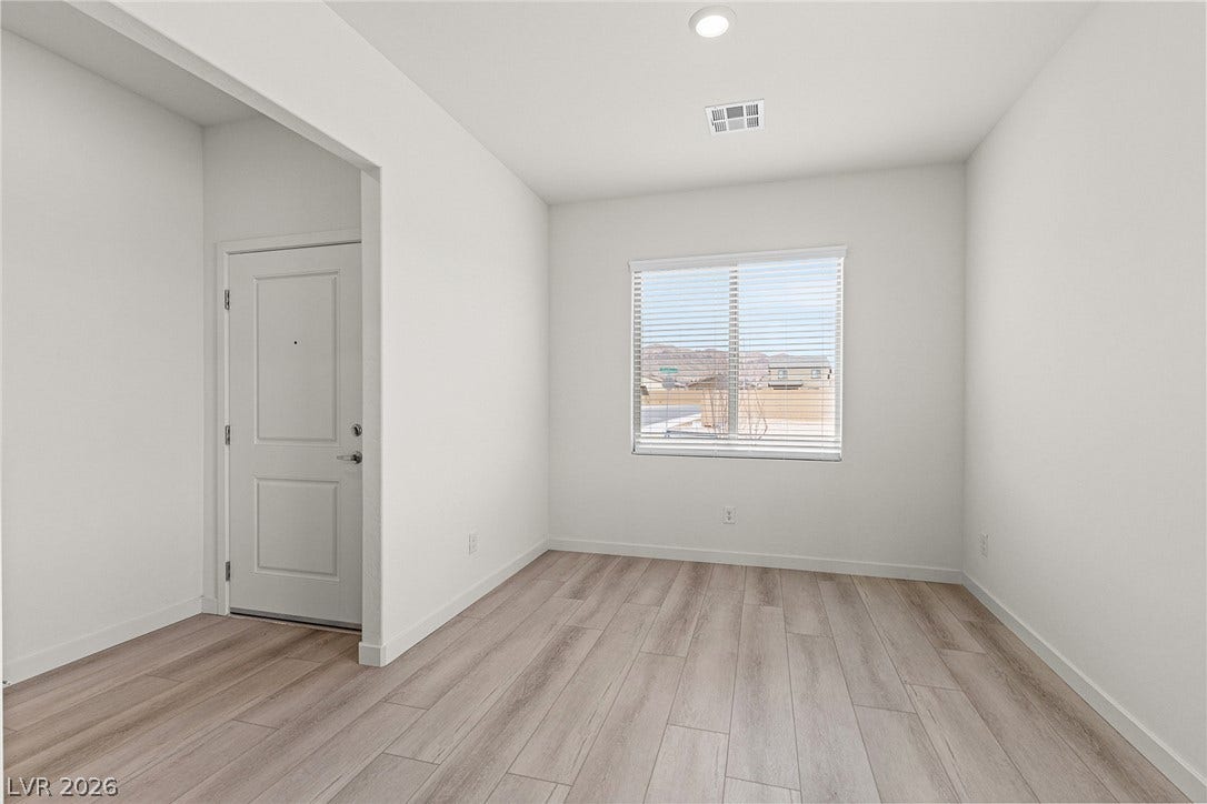 A well-lit entry area features wood flooring and a street view.