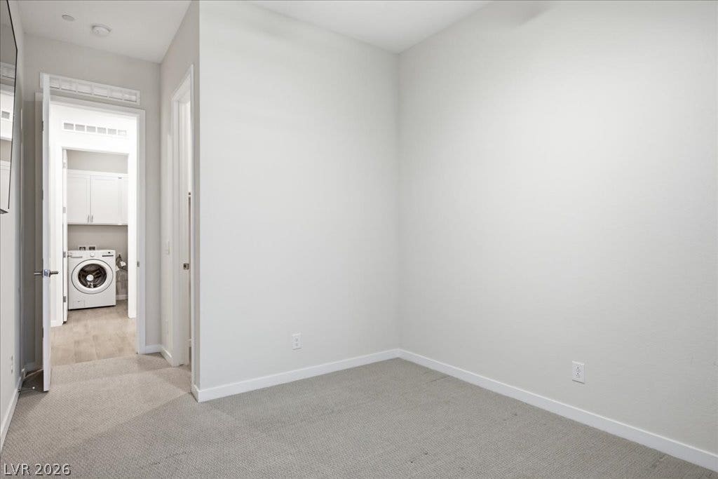 847 Eaton Falls Street, Henderson, NV 89011 A well-lit, neutral-toned room with plush carpeting offers versatile space and easy access to a dedicated laundry area.