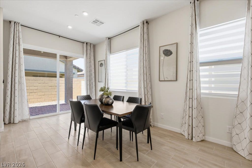 847 Eaton Falls Street, Henderson, NV 89011 A refined dining space offers ample natural light and seamless indoor-outdoor access through sliding glass doors.