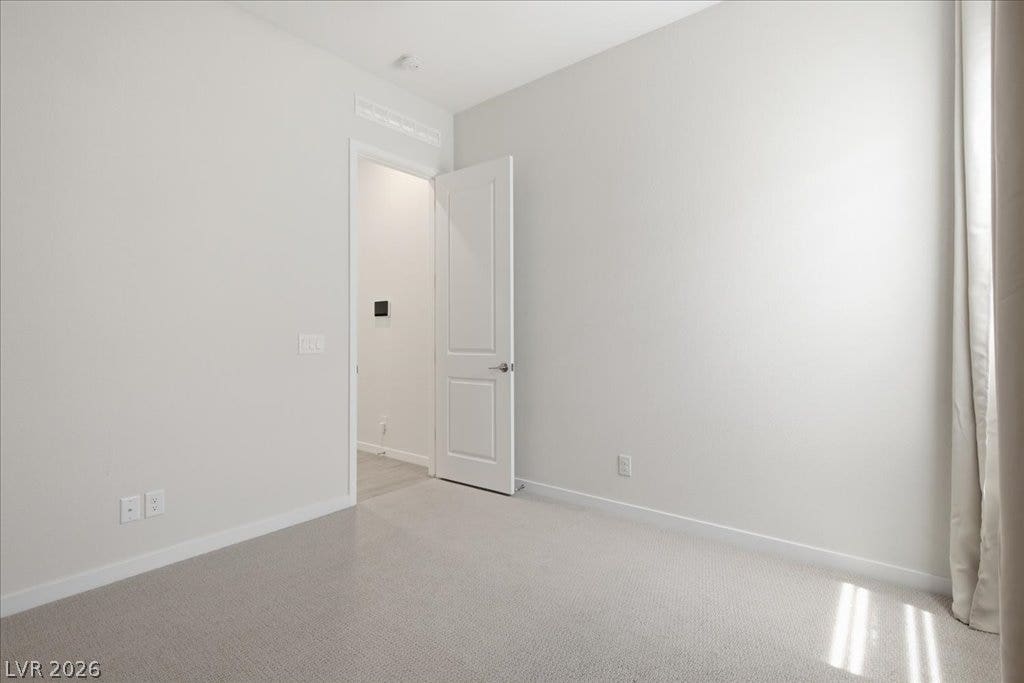 847 Eaton Falls Street, Henderson, NV 89011 A well-lit bedroom features plush carpeting and a doorway leading to an adjacent space.
