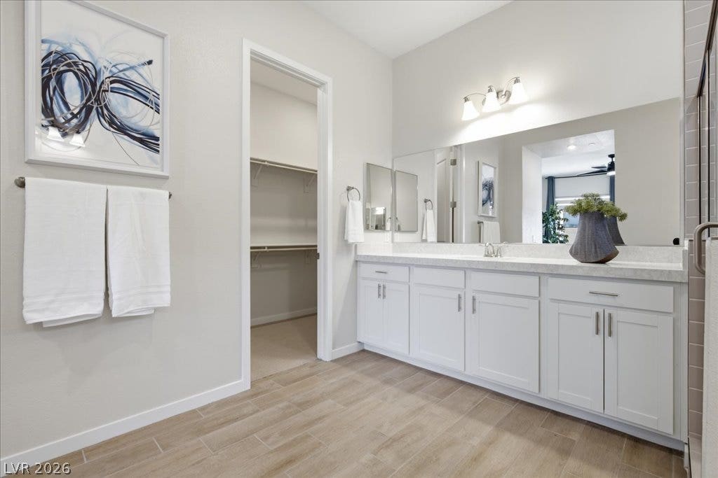 847 Eaton Falls Street, Henderson, NV 89011 A well-lit bathroom features a spacious vanity with dual sinks, leading into a convenient walk-in closet.
