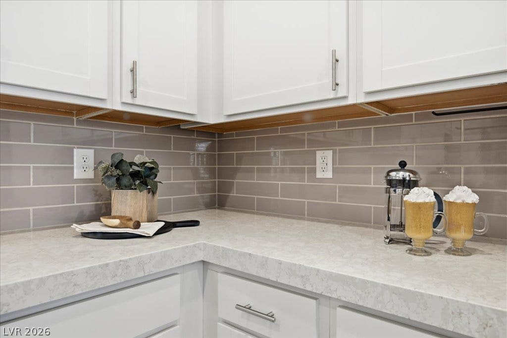 847 Eaton Falls Street, Henderson, NV 89011 White cabinetry beautifully contrasts the sleek subway tile backsplash in this inviting kitchen space.