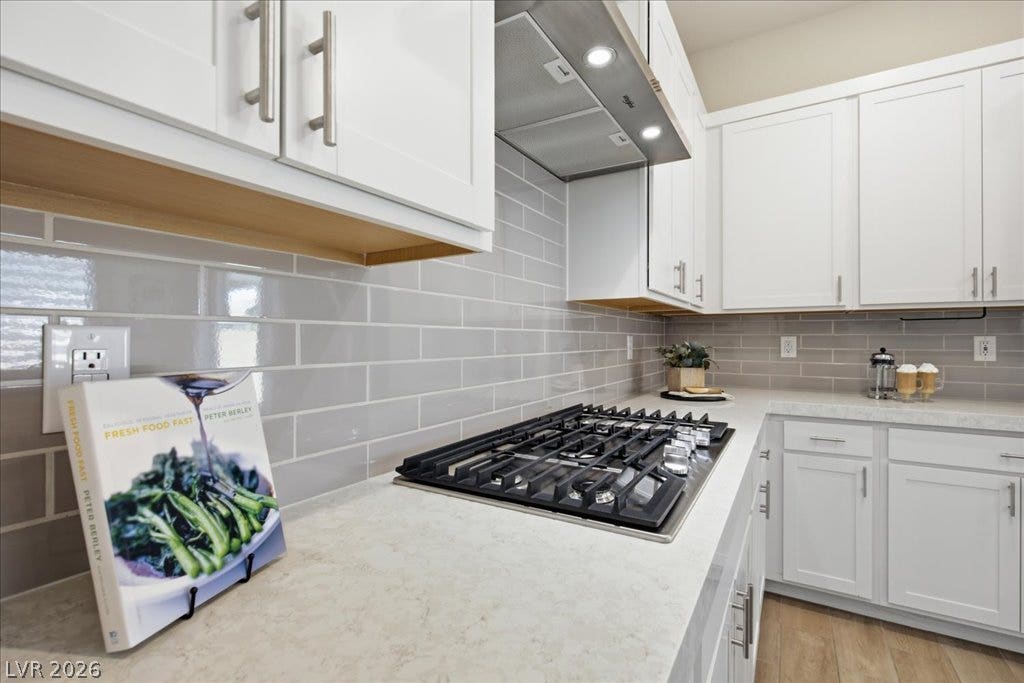 847 Eaton Falls Street, Henderson, NV 89011 Modern kitchen with sleek cabinetry and a high-performance gas cooktop for culinary endeavors.