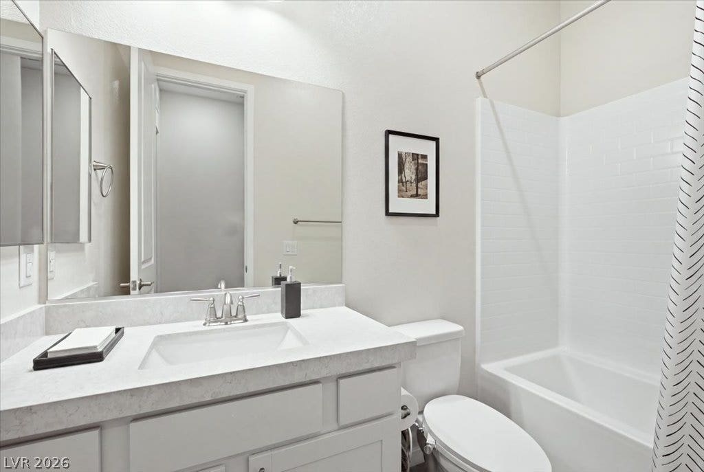 847 Eaton Falls Street, Henderson, NV 89011 A well-lit bathroom features a spacious vanity with an integrated sink, a toilet, and a combined tub and shower.
