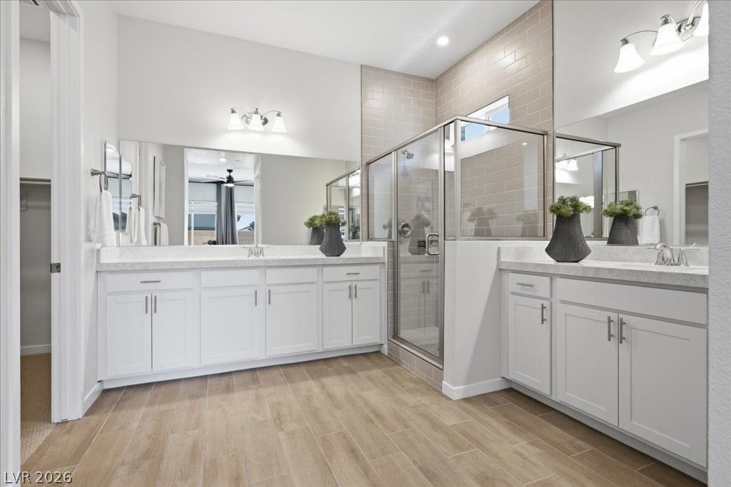 847 Eaton Falls Street, Henderson, NV 89011 Dual vanities and a spacious glass-enclosed shower create a practical and well-lit bathroom retreat.