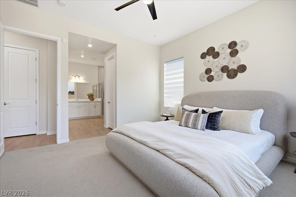 847 Eaton Falls Street, Henderson, NV 89011 A quiet retreat, this bedroom offers plush carpeting and an en-suite bathroom with dual vanities.