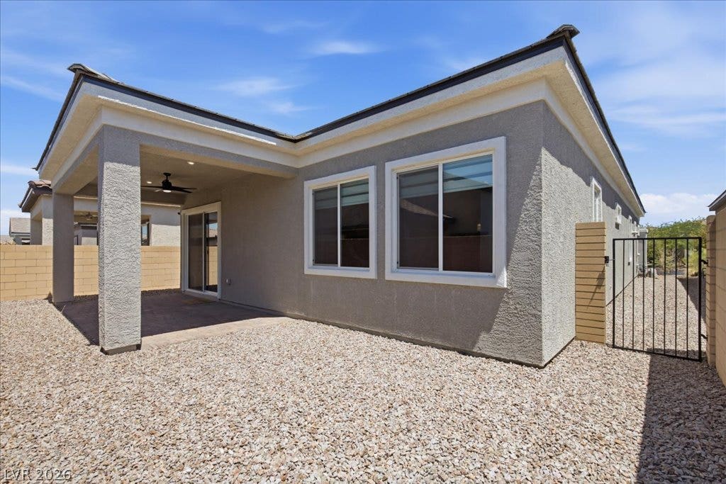 847 Eaton Falls Street, Henderson, NV 89011 A spacious gravel backyard offers low-maintenance outdoor living, complemented by a covered patio with a ceiling fan.