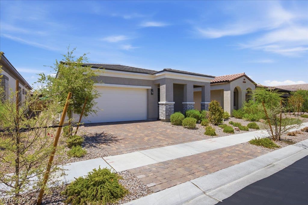 847 Eaton Falls Street, Henderson, NV 89011 A well-maintained desert landscape frames this single-story residence with a paver driveway.