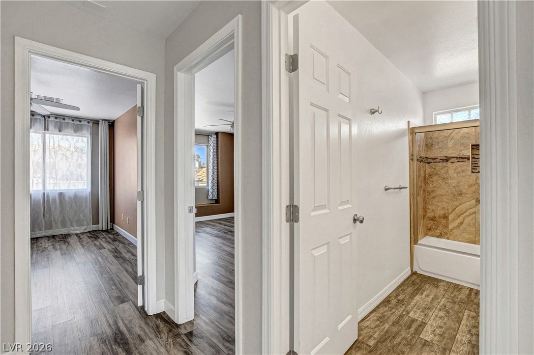 8308 Raphael Court, Las Vegas, NV 89129 Laminated flooring guides you through this home, revealing a bathroom with a tiled shower.