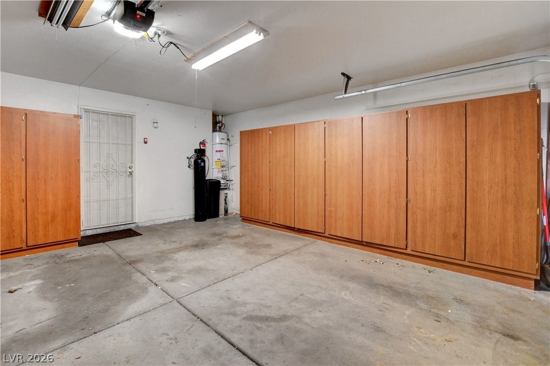 8308 Raphael Court, Las Vegas, NV 89129 Functional garage offering substantial storage with built-in cabinetry and durable concrete flooring.