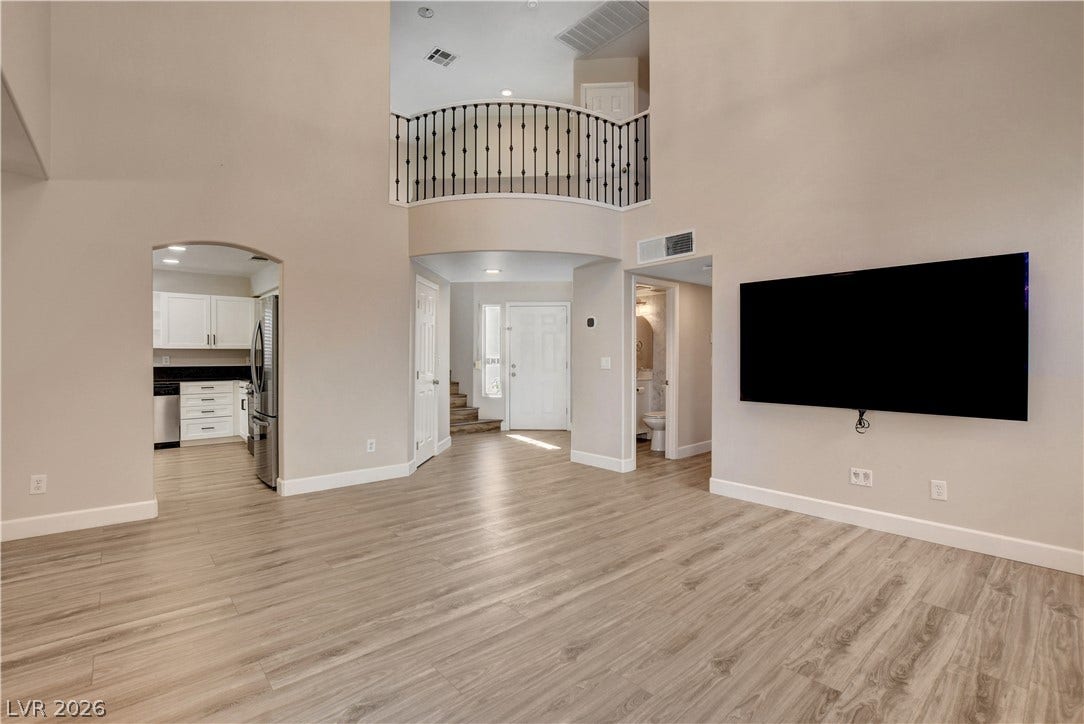 8308 Raphael Court, Las Vegas, NV 89129 A spacious, airy living area with soaring ceilings and light wood-look flooring flows seamlessly into the kitchen and entryway.