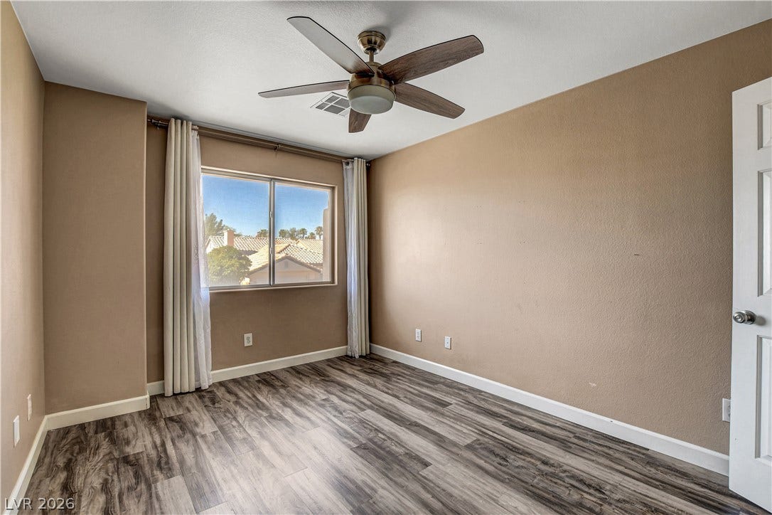 8308 Raphael Court, Las Vegas, NV 89129 A quiet bedroom retreat features ample natural illumination, a cooling ceiling fan, and durable wood-look flooring.