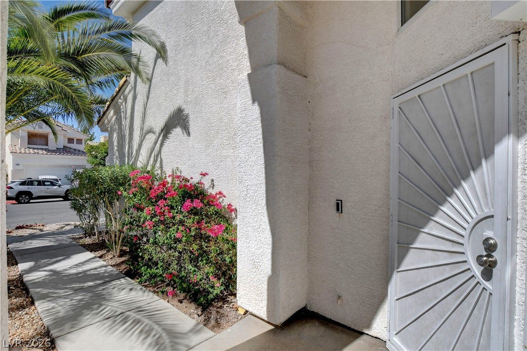 8308 Raphael Court, Las Vegas, NV 89129 A private entrance leads past a lush garden, providing a serene welcome to the home.