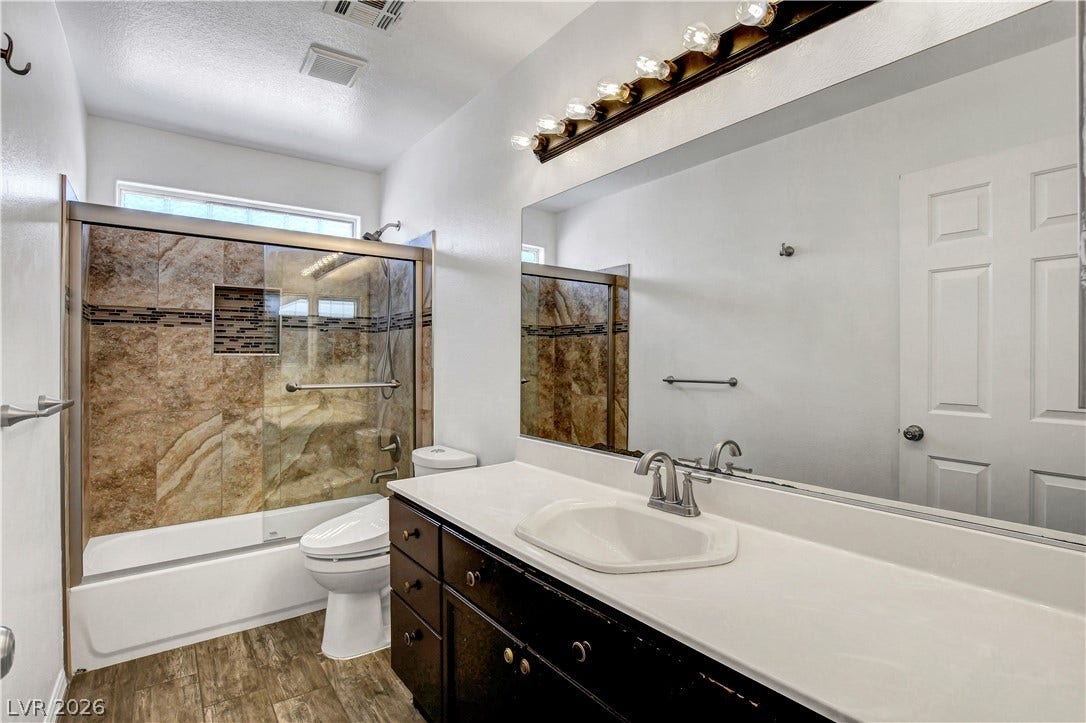 8308 Raphael Court, Las Vegas, NV 89129 A well-appointed bathroom features a practical vanity and a tub with an integrated shower.
