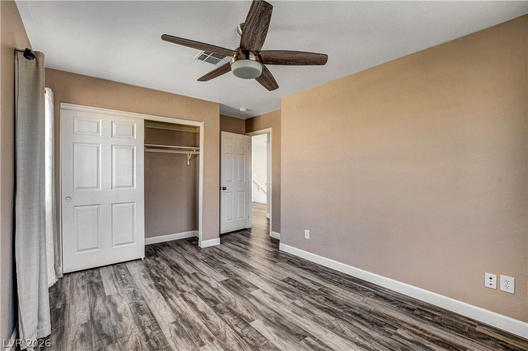 8308 Raphael Court, Las Vegas, NV 89129 An inviting bedroom features a wood-look floor, a built-in closet, and a contemporary ceiling fan for year-round comfort.