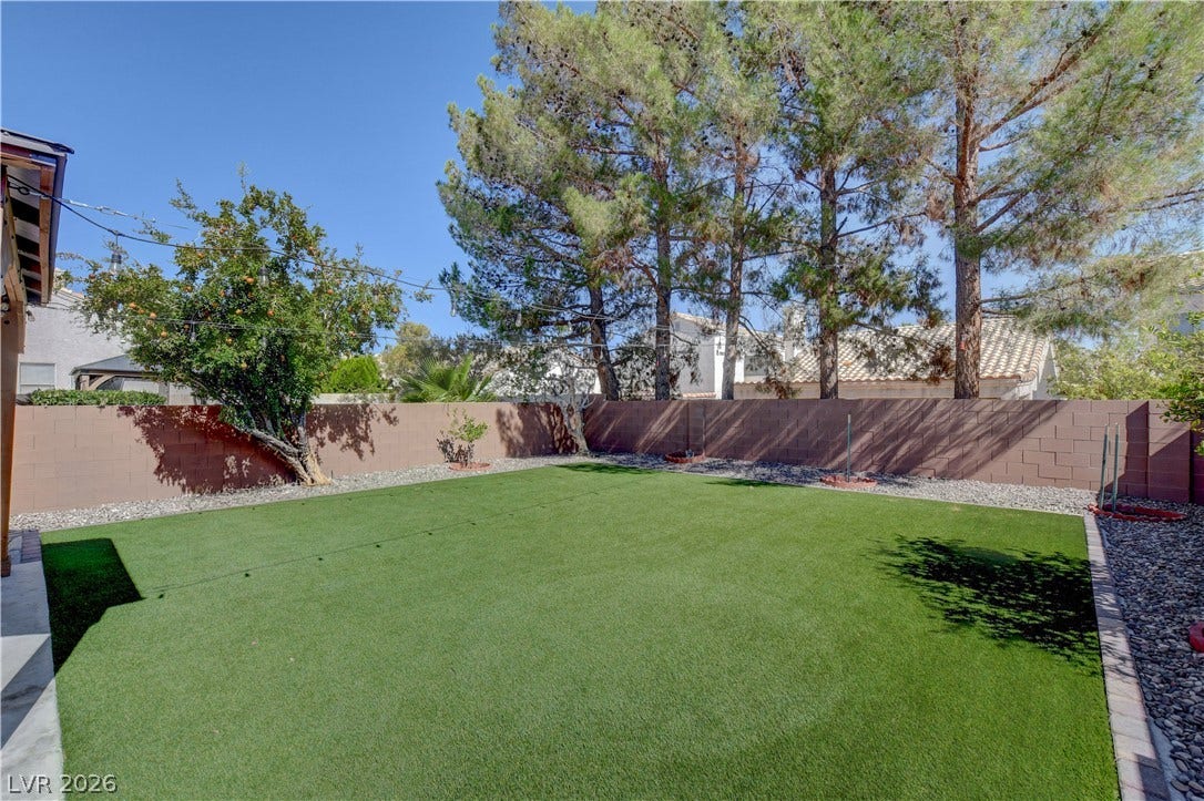 8308 Raphael Court, Las Vegas, NV 89129 A low-maintenance backyard retreat features lush artificial turf and mature shade trees.