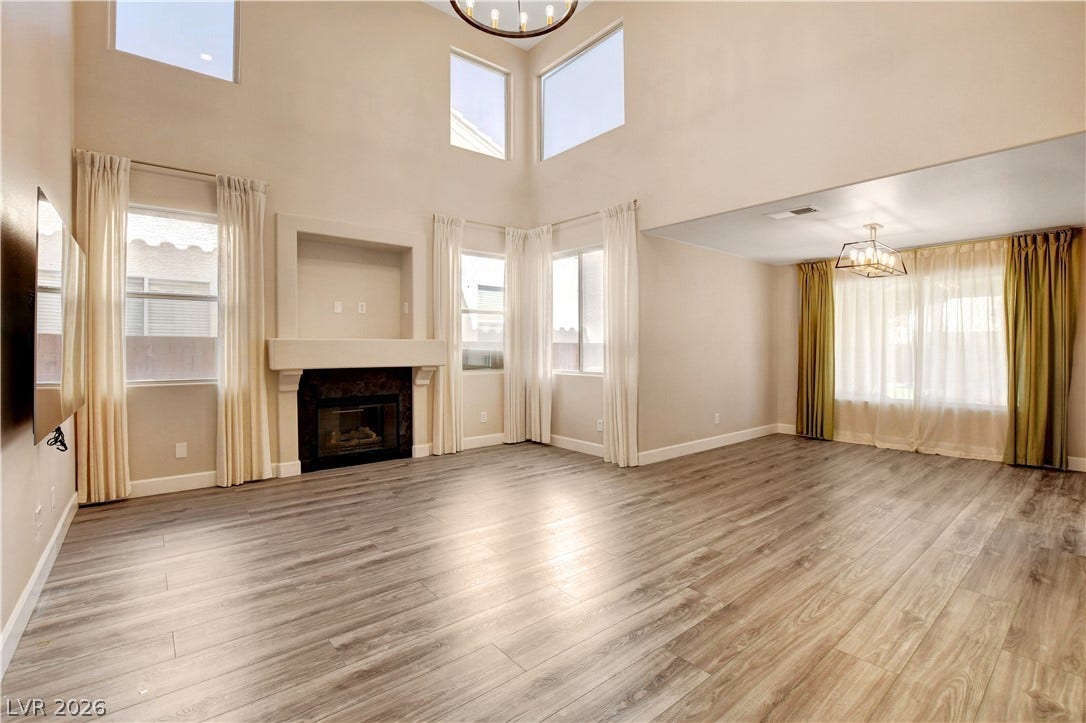 8308 Raphael Court, Las Vegas, NV 89129 A spacious living area features high ceilings, a cozy fireplace, and rich wood flooring.