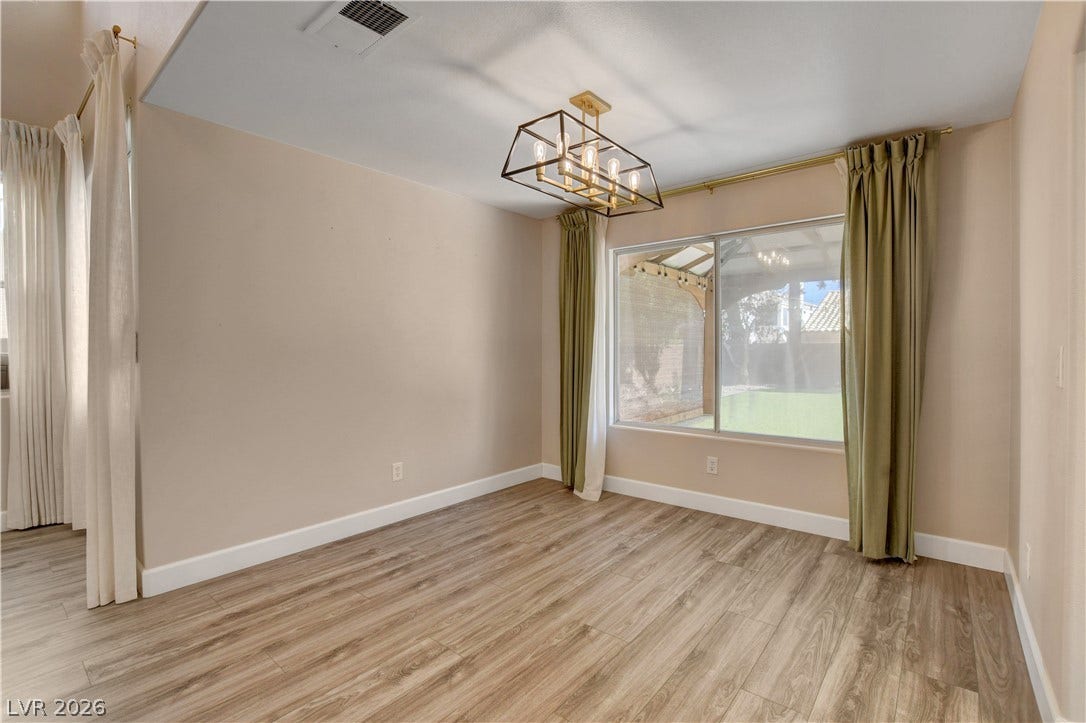 8308 Raphael Court, Las Vegas, NV 89129 A refined interior space features rich wood flooring, a modern chandelier, and ample natural light.