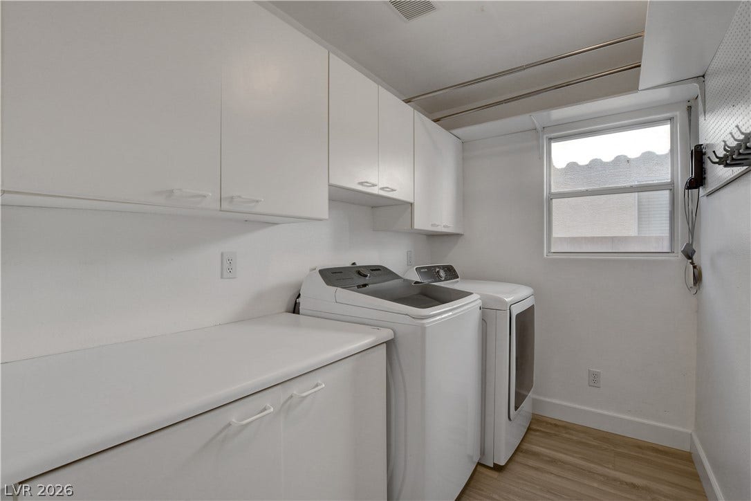 8308 Raphael Court, Las Vegas, NV 89129 A well-appointed utility area featuring ample cabinetry and convenient appliances for laundry tasks.