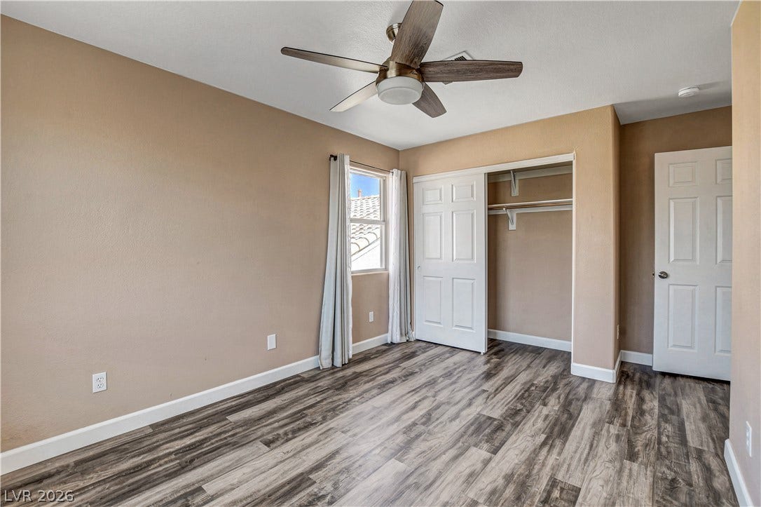 8308 Raphael Court, Las Vegas, NV 89129 A quiet bedroom showcases a ceiling fan, a window, and wood-look flooring.
