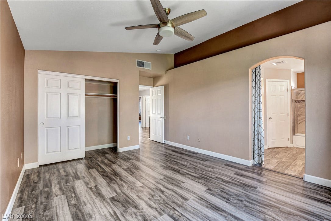 8308 Raphael Court, Las Vegas, NV 89129 Laminate flooring and a vaulted ceiling elevate this primary bedroom.
