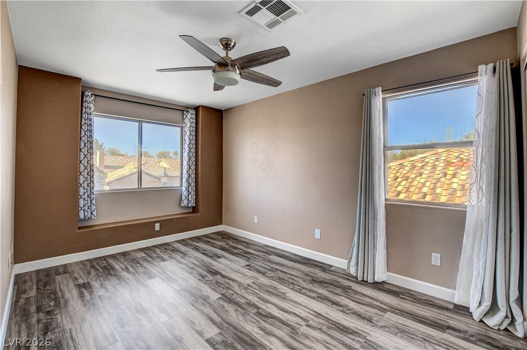 8308 Raphael Court, Las Vegas, NV 89129 Well-lit sleeping quarters with rich wood-look flooring and a ceiling fan for year-round comfort.