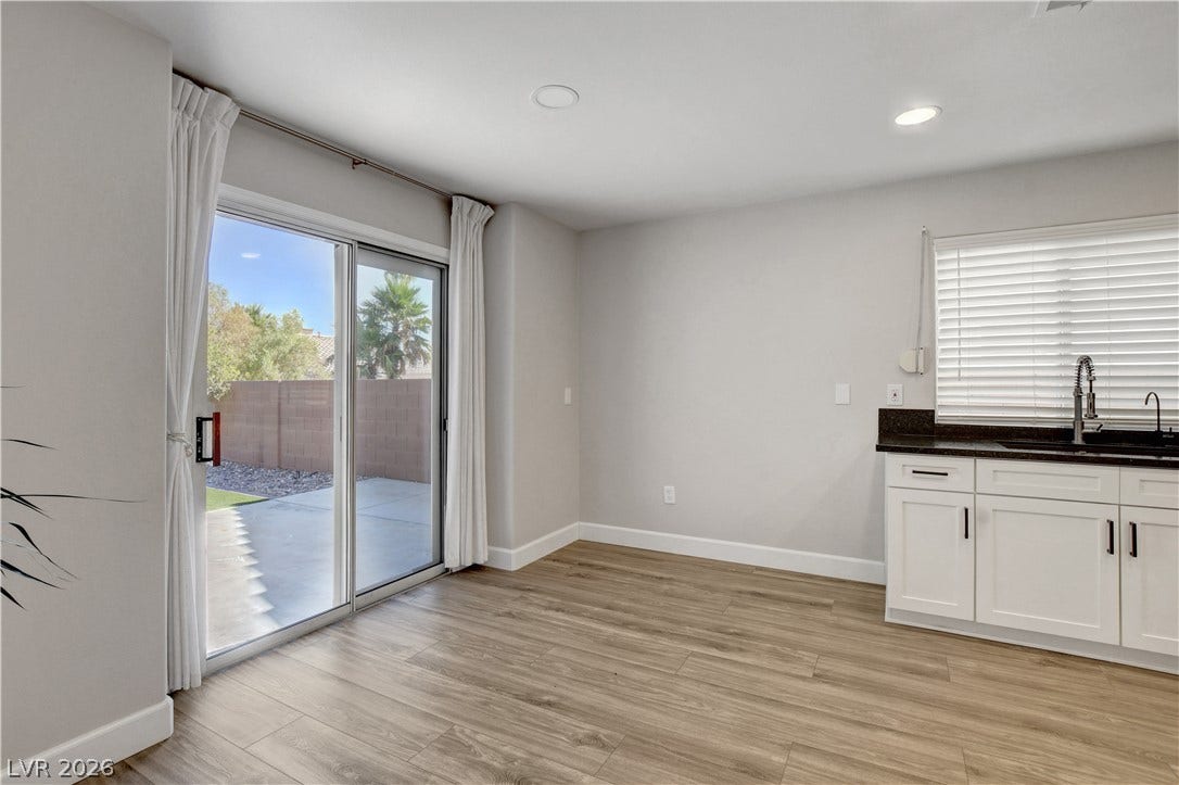 8308 Raphael Court, Las Vegas, NV 89129 A well-lit area with wood-look flooring and sliding glass doors that open to a private outdoor space.
