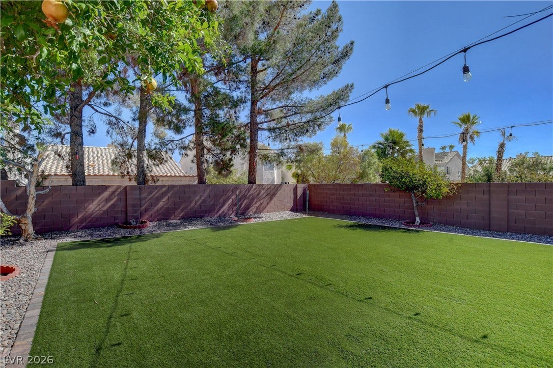8308 Raphael Court, Las Vegas, NV 89129 A private yard with artificial turf and a sturdy block fence, ideal for recreation.