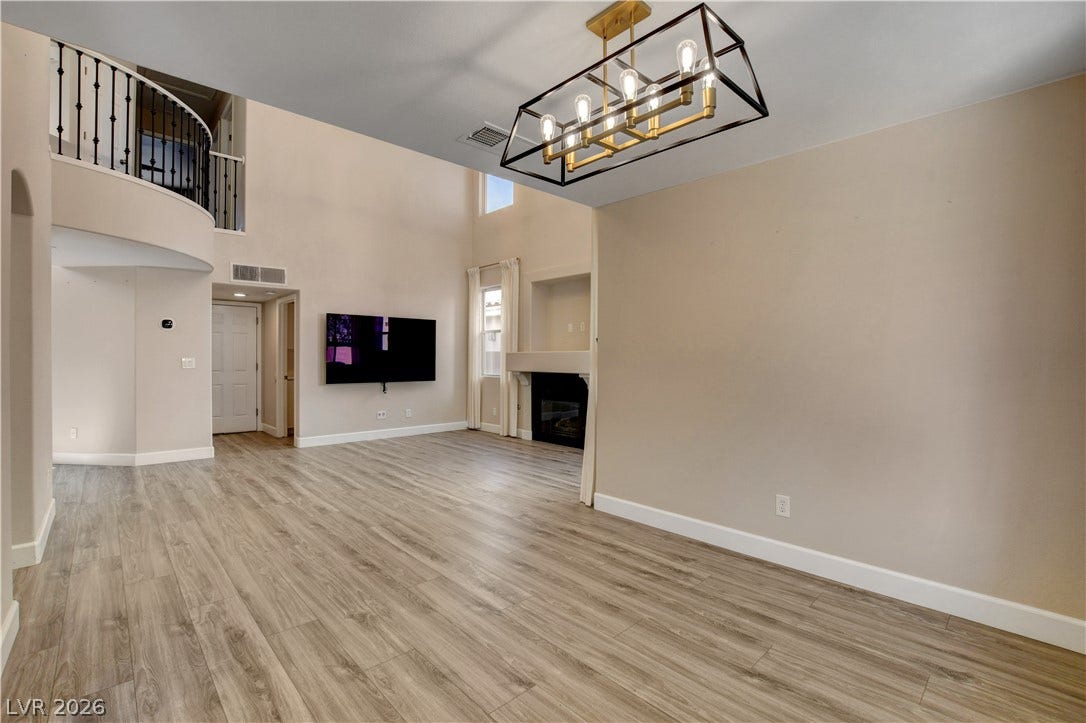 8308 Raphael Court, Las Vegas, NV 89129 A spacious living area with soaring ceilings and a stylish fireplace, perfect for gatherings.