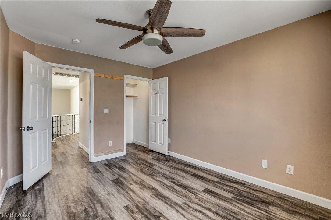 8308 Raphael Court, Las Vegas, NV 89129 A comfortable bedroom with wood plank flooring and a modern ceiling fan.