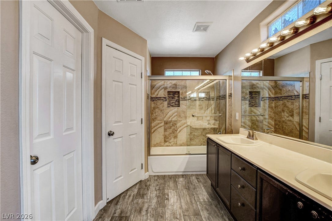 8308 Raphael Court, Las Vegas, NV 89129 Double vanity and tiled shower with glass enclosure provide luxurious functionality in this primary bath.