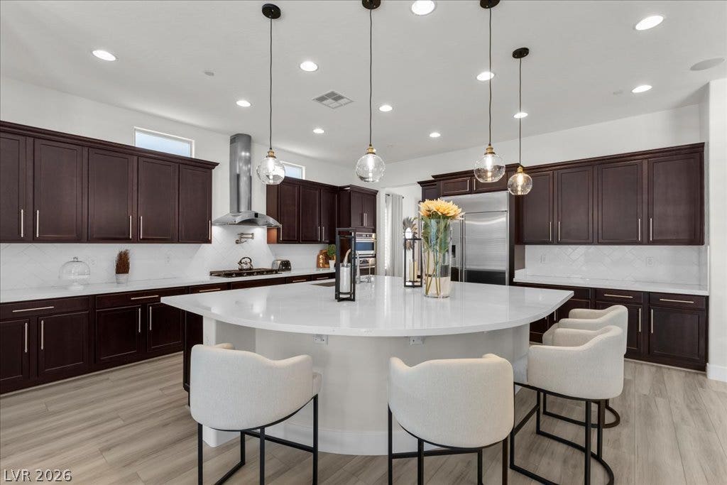 2828 Josephine Drive, Henderson, NV 89044 A well-appointed kitchen features ample rich wood cabinetry and a large, inviting island, perfect for entertaining.