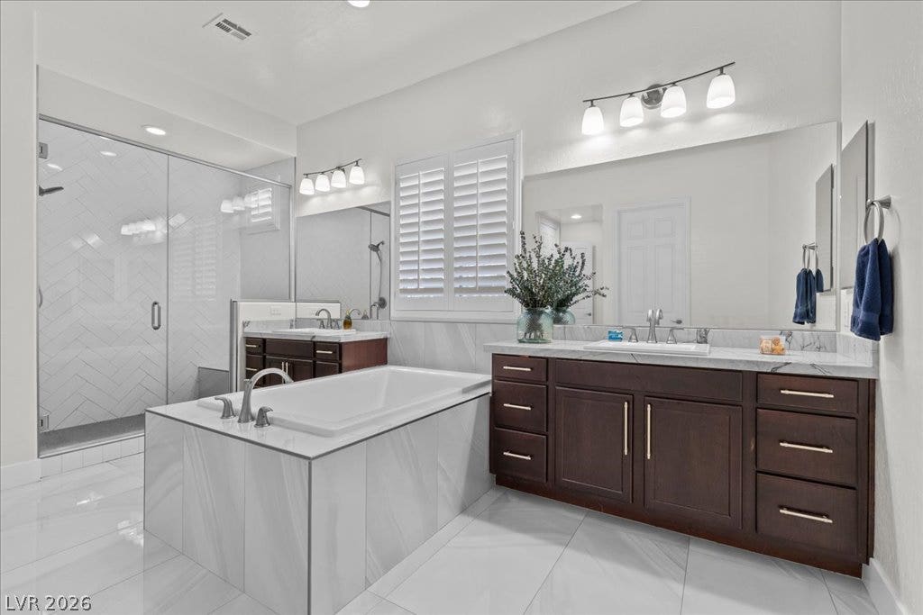 2828 Josephine Drive, Henderson, NV 89044 Luxurious bathroom featuring dual vanities, a spacious soaking tub, and a modern walk-in shower.