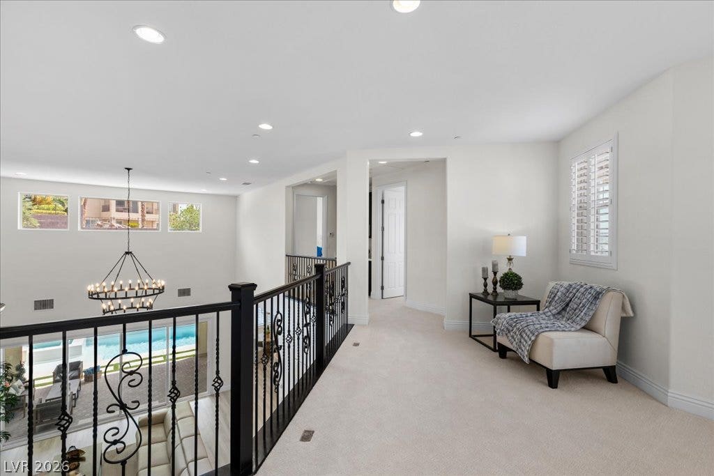 2828 Josephine Drive, Henderson, NV 89044 Upper-level landing with plush carpeting overlooks the main living area, offering a cozy sitting nook and abundant natural light.