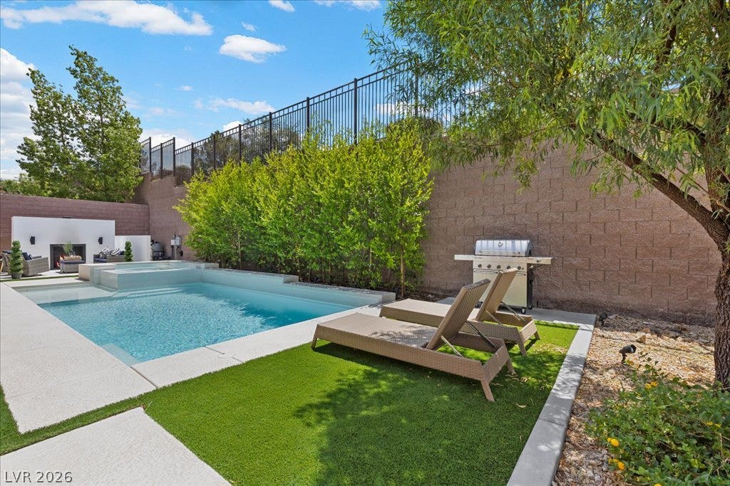 2828 Josephine Drive, Henderson, NV 89044 An inviting backyard oasis offers a sparkling pool and spa, alongside an outdoor fireplace and built-in barbecue.