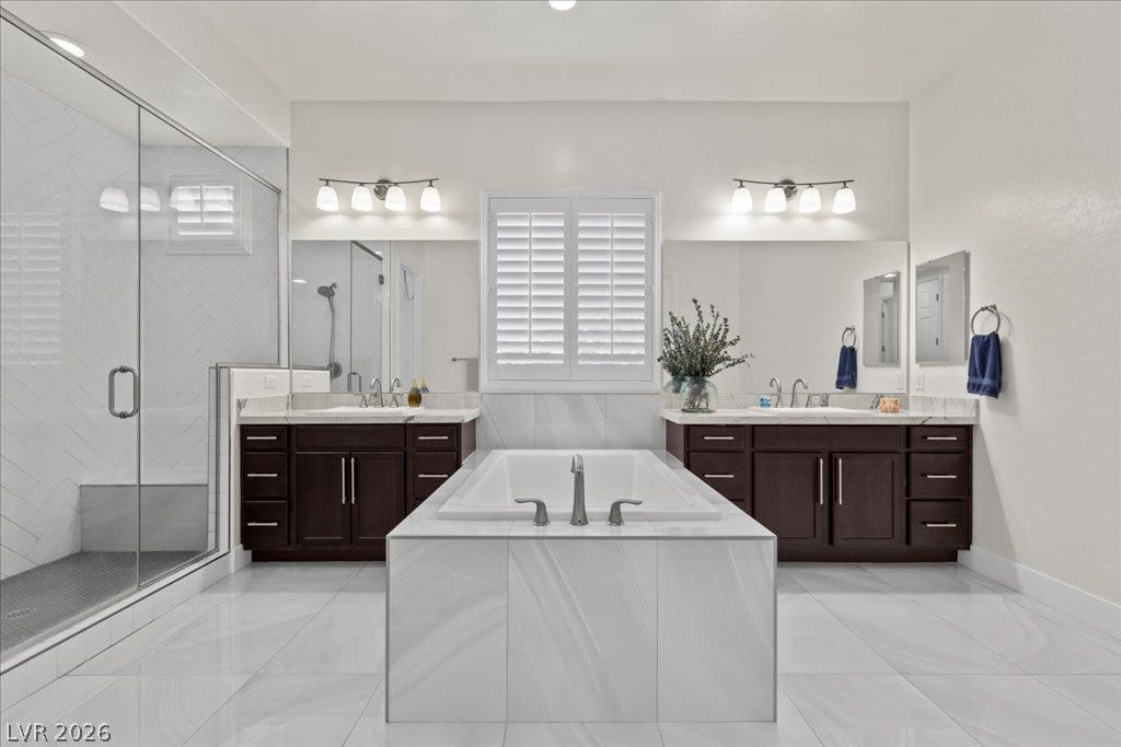 2828 Josephine Drive, Henderson, NV 89044 Indulge in a tranquil retreat featuring dual vanities, a spacious soaking tub, and a glass-enclosed shower.