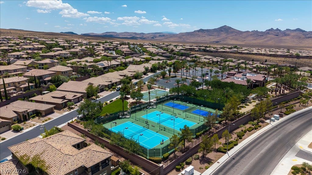 2828 Josephine Drive, Henderson, NV 89044 An aerial perspective reveals a vibrant community nestled among desert mountains, featuring extensive tennis and pickleball courts.