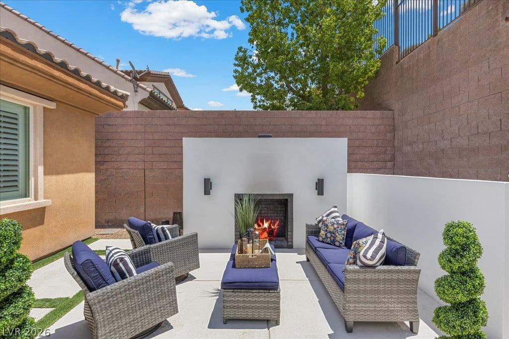 2828 Josephine Drive, Henderson, NV 89044 An inviting outdoor living area features a built-in fireplace, perfect for evening gatherings.