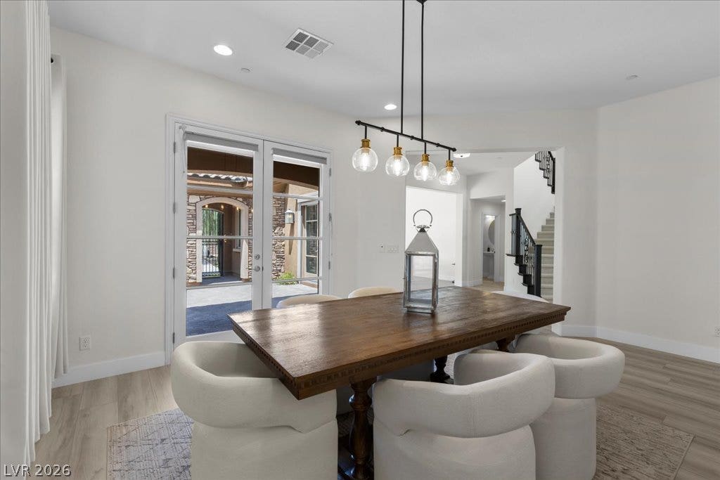 2828 Josephine Drive, Henderson, NV 89044 Dining area with contemporary chandelier, wood-look flooring, and a view of the courtyard, protected with rolling metal shutters