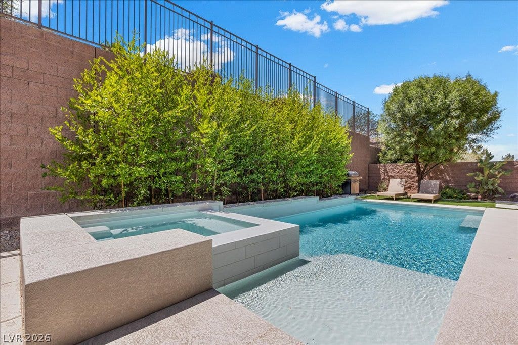 2828 Josephine Drive, Henderson, NV 89044 Lush landscaping frames a sparkling pool and spa, creating a serene backyard oasis.