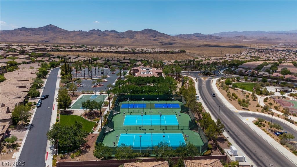 2828 Josephine Drive, Henderson, NV 89044 An aerial perspective showcases a residential community nestled against mountains, featuring multiple tennis courts and a basketball court.