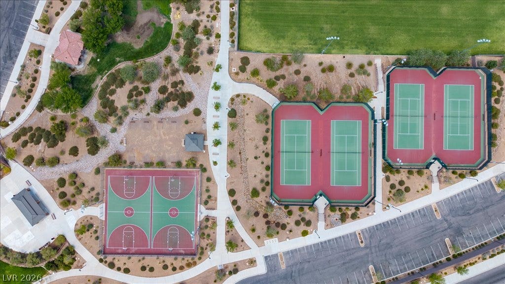 2828 Josephine Drive, Henderson, NV 89044 An aerial view showcases meticulously maintained tennis courts, a basketball court, and walking paths, all surrounded by xeriscaping and open spaces.