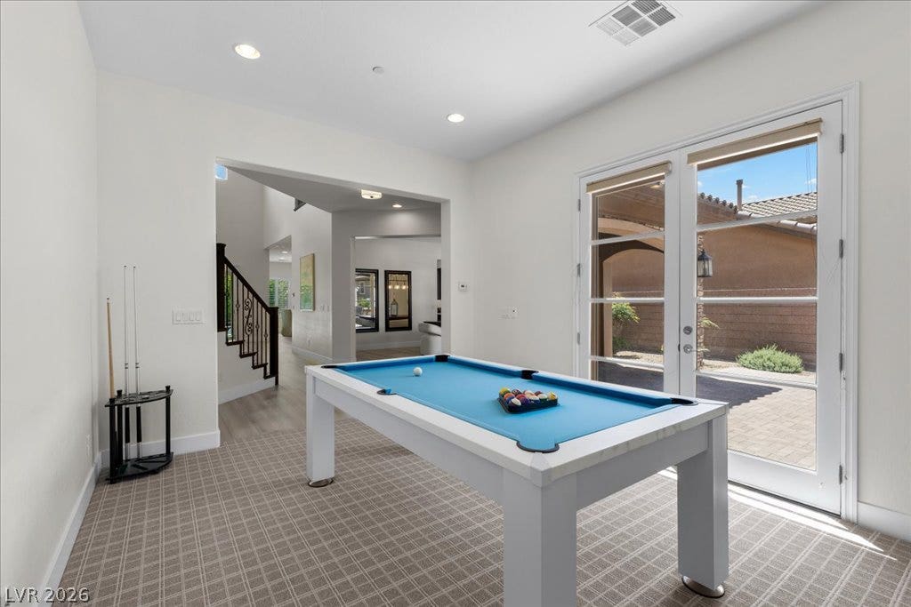 2828 Josephine Drive, Henderson, NV 89044 A spacious game room features a billiards table and direct patio access through elegant French doors, protected with rolling metal shutters
