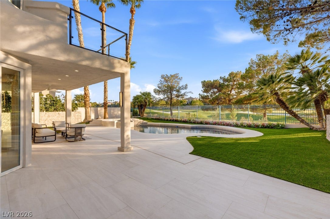 An inviting covered patio offers seamless indoor-outdoor living, with a sparkling pool overlooking verdant golf course greens.