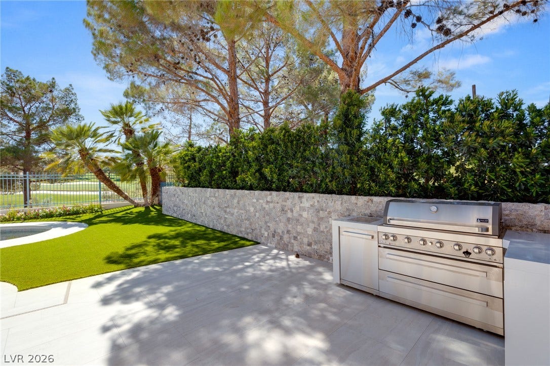 An outdoor grilling station provides an ideal setup for alfresco entertaining with a view of the lush golf course.