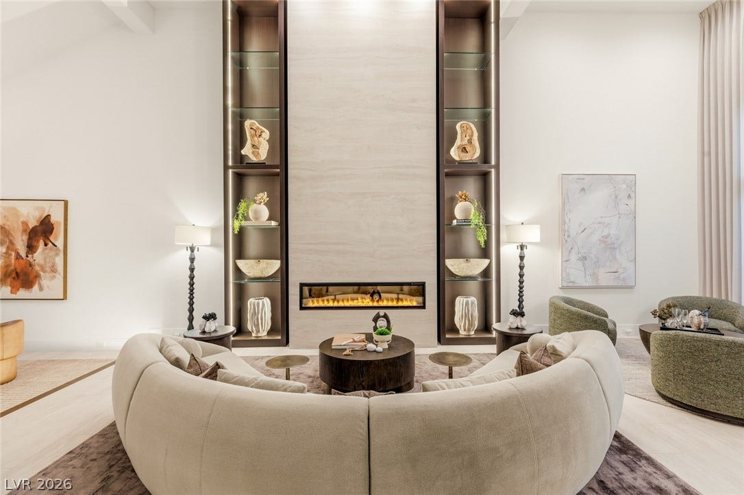 A striking linear fireplace anchors this living space, flanked by illuminated display shelving.